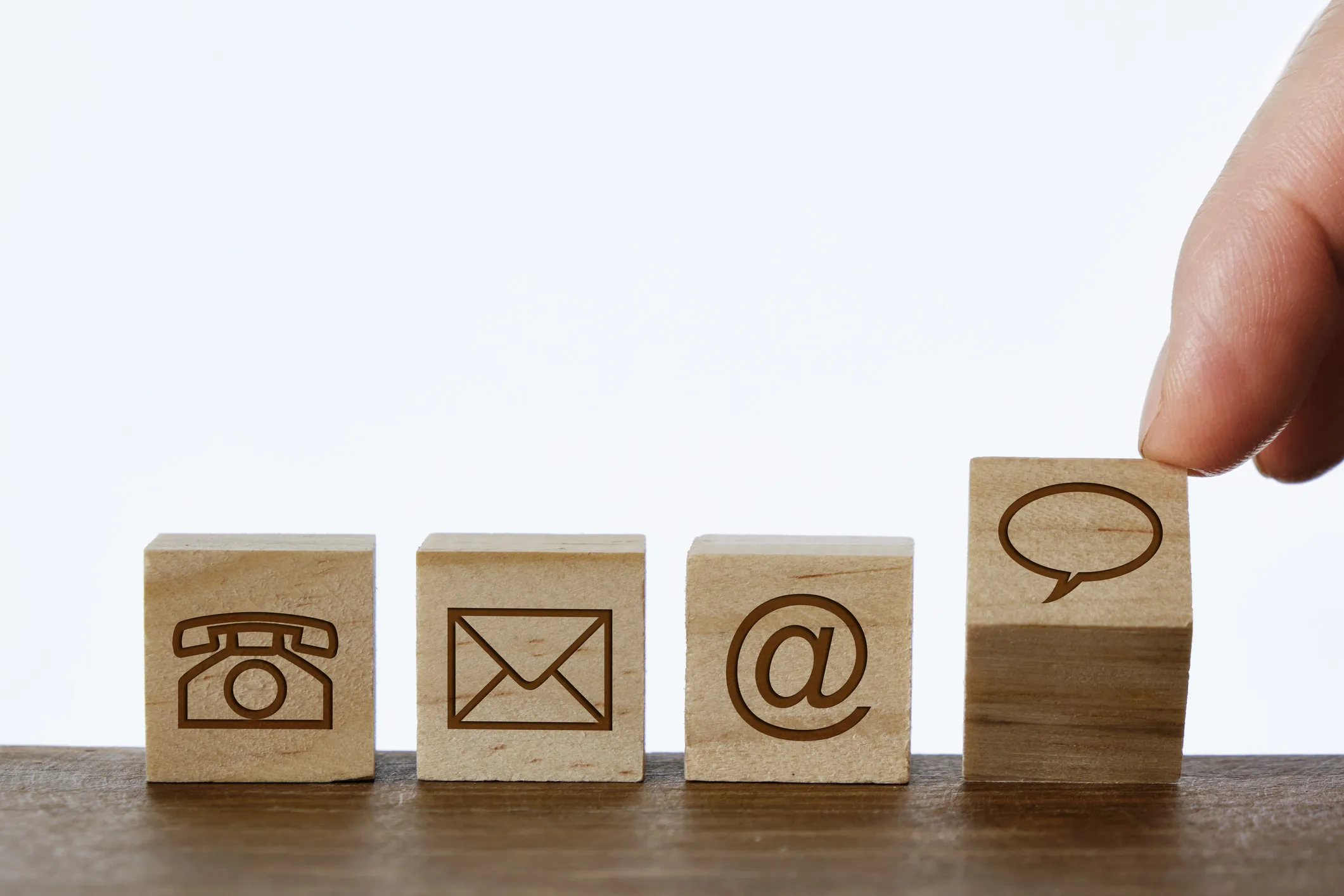 Wooden blocks with phone, mail, email, and chat icons