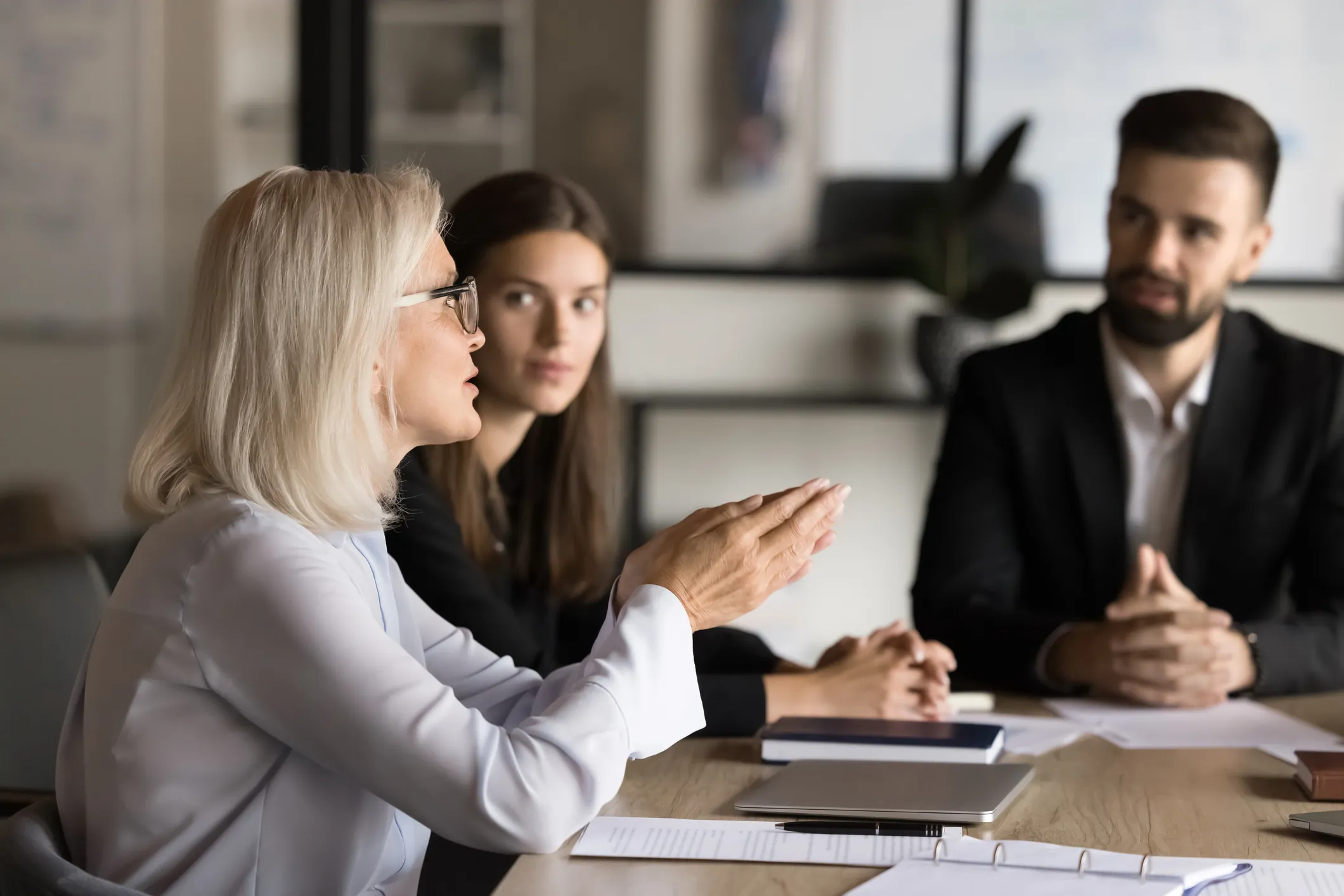 Three people discussing at a conference table