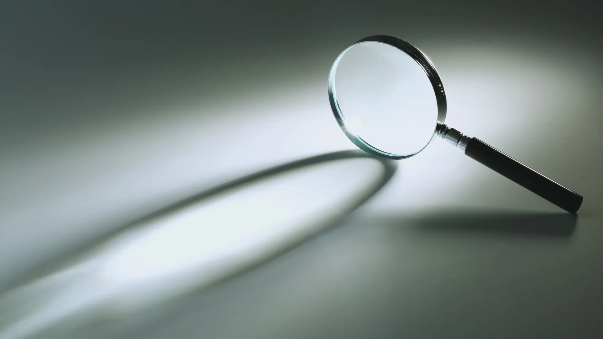 Magnifying glass casting a shadow on a light surface