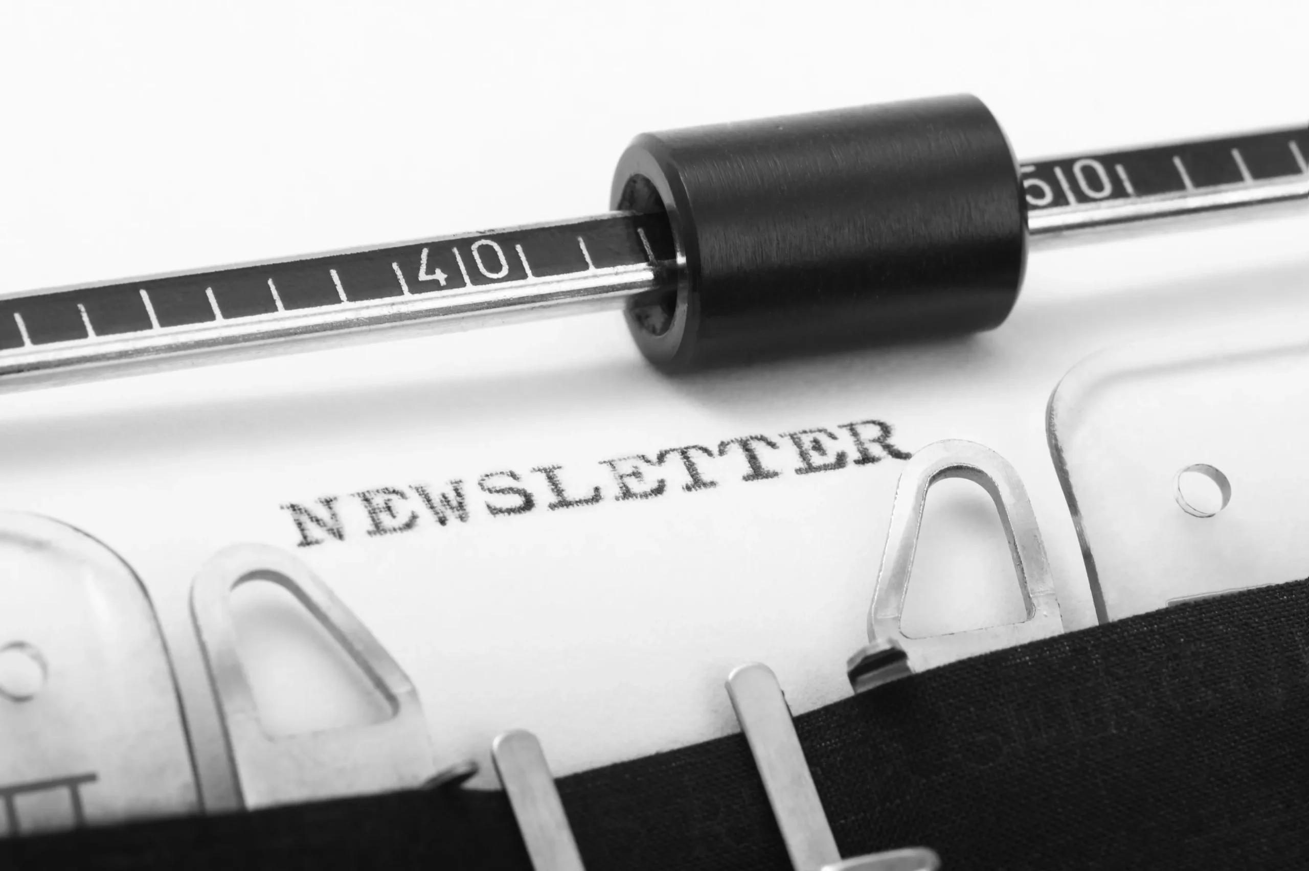 Typewriter typing the word "NEWSLETTER" on paper