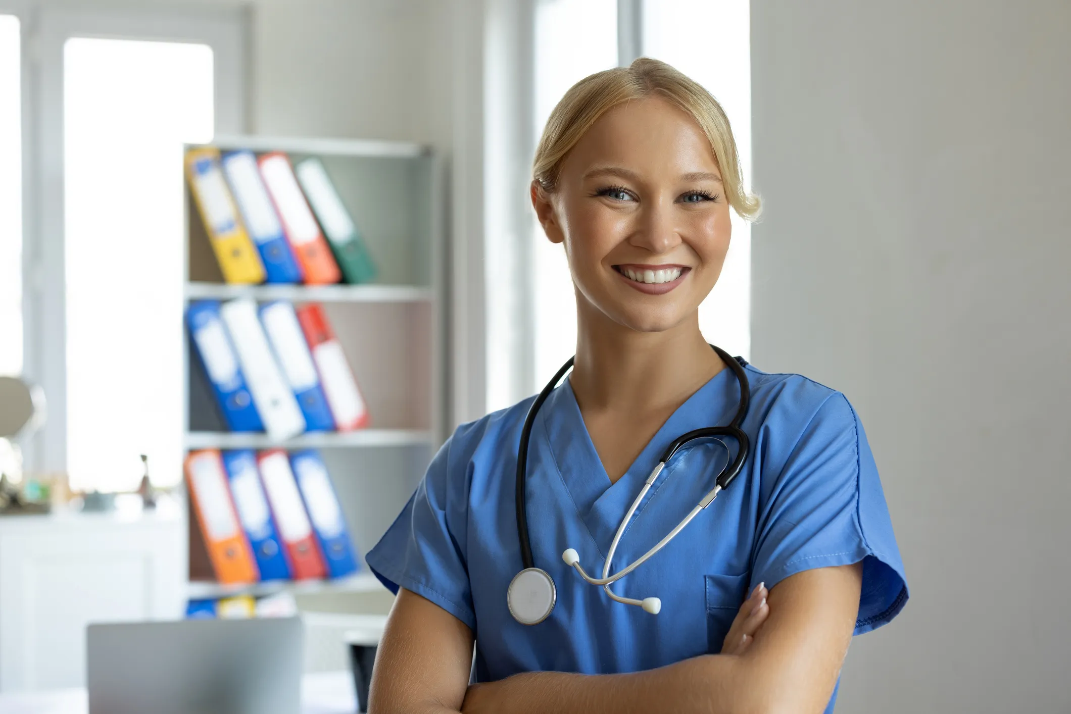 A healthcare professional in blue scrubs with stethoscope