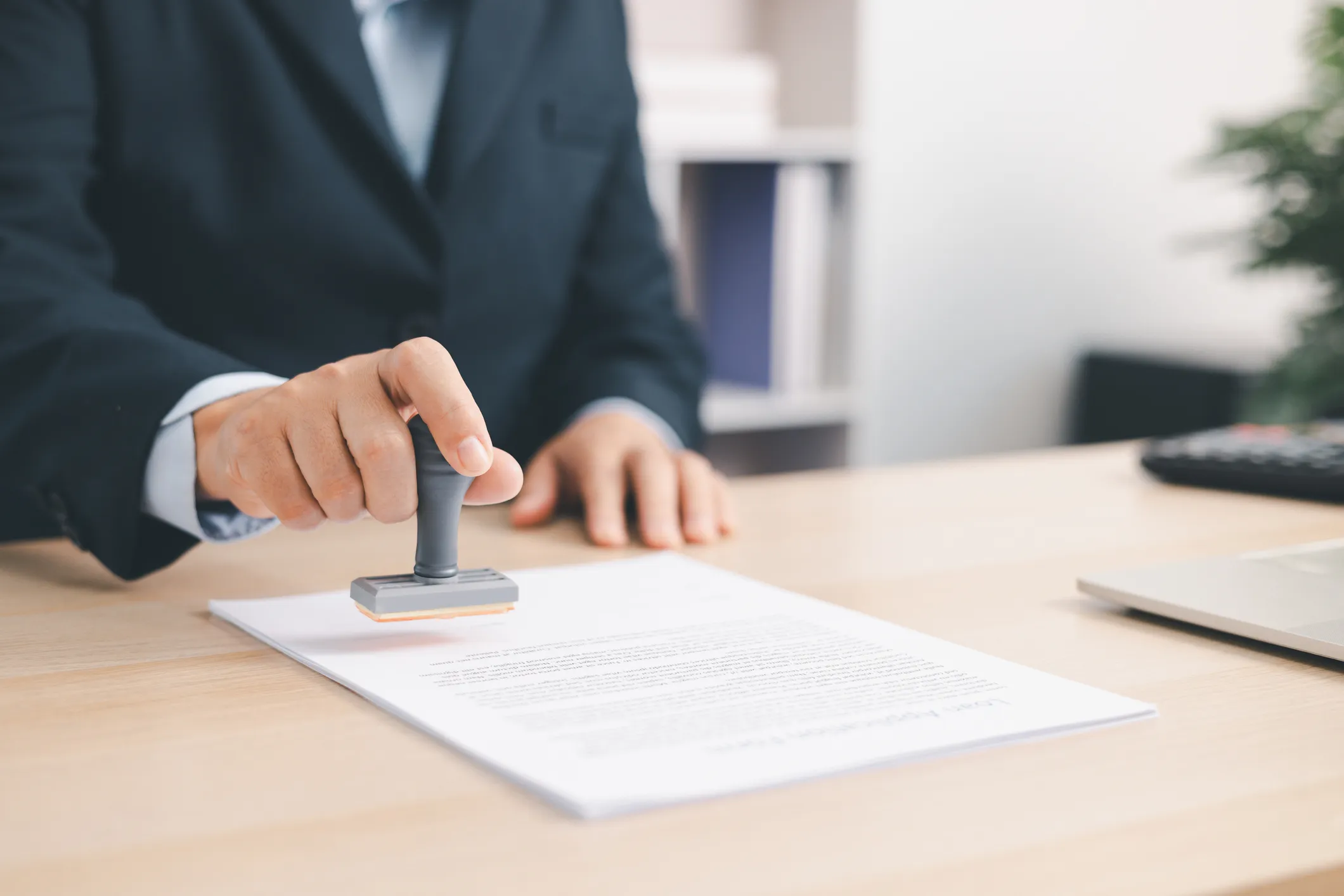 Person stamping a document using a rubber stamp