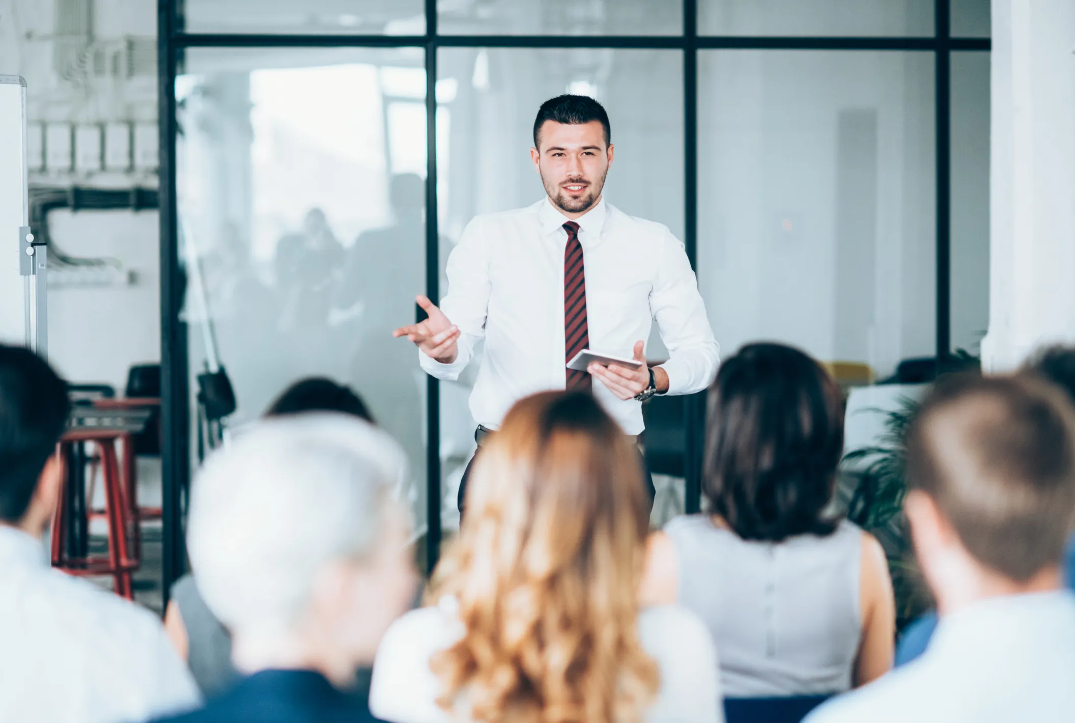 Man giving a presentation to a seated audience in an office setting
