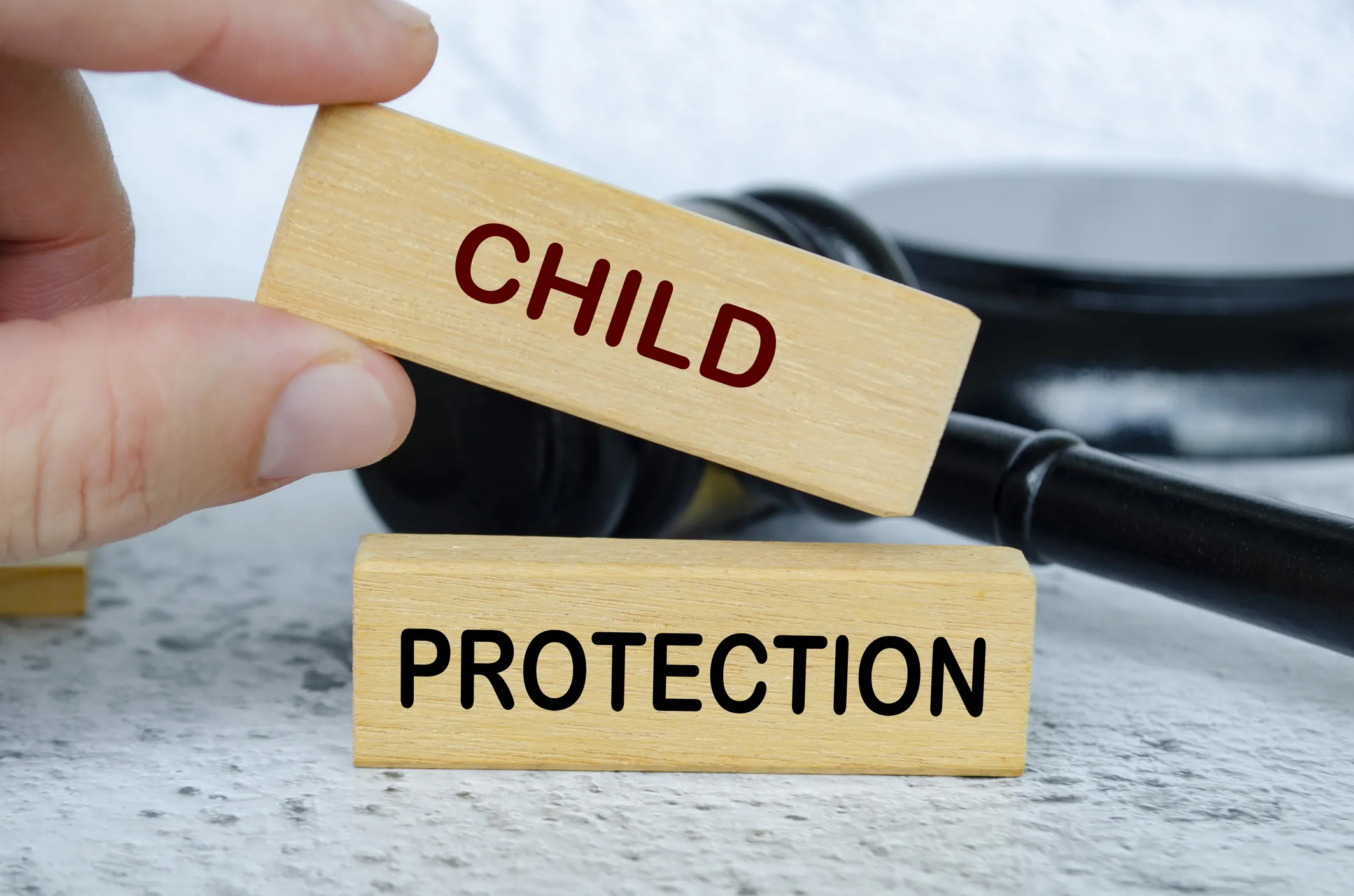 Wooden blocks with the words "CHILD" and "PROTECTION" next to a gavel