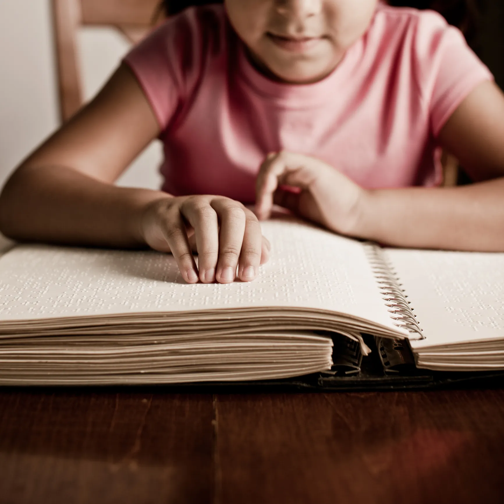 Child reading a Braille book