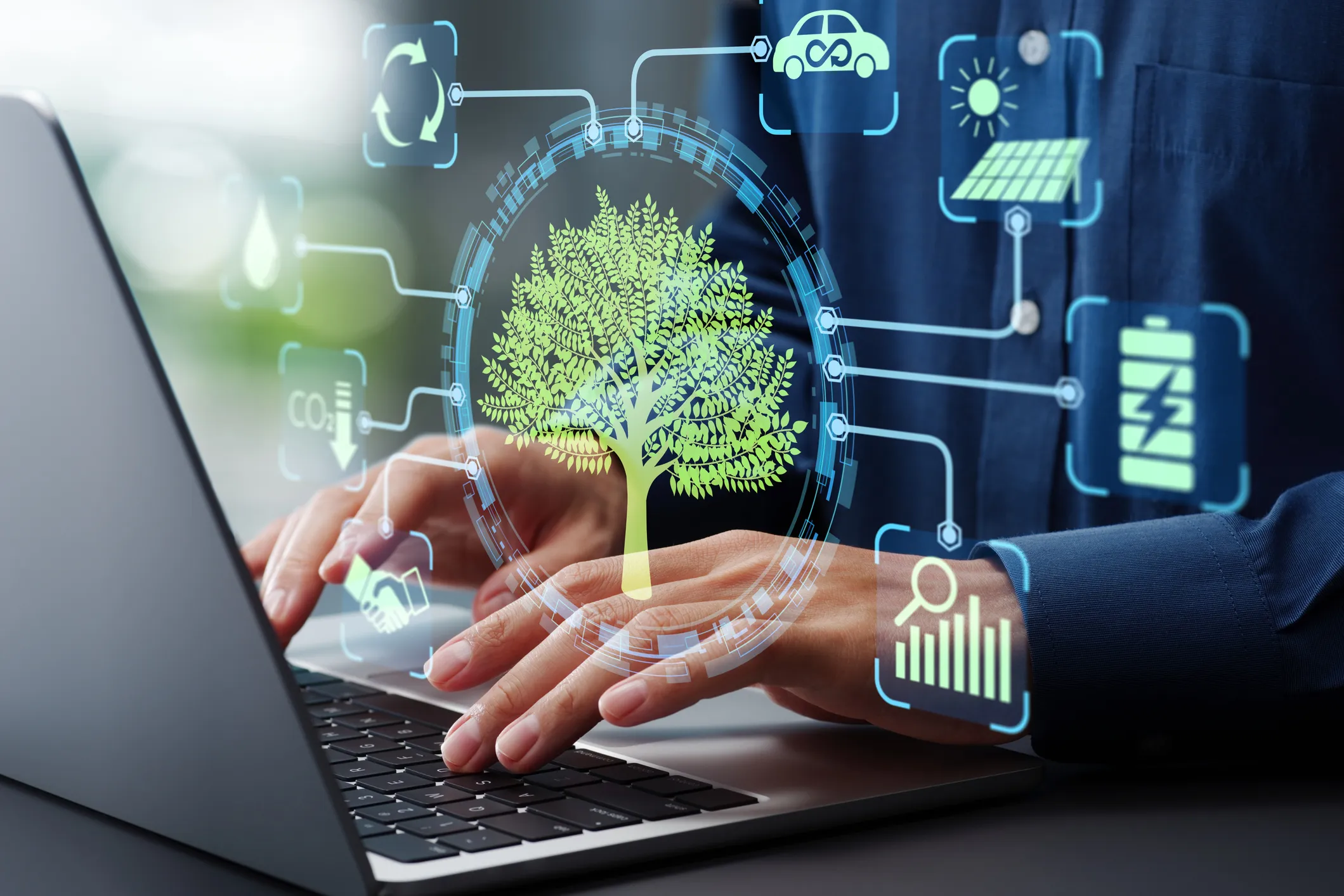 Person typing on laptop with digital tree and eco-friendly technology icons overlay