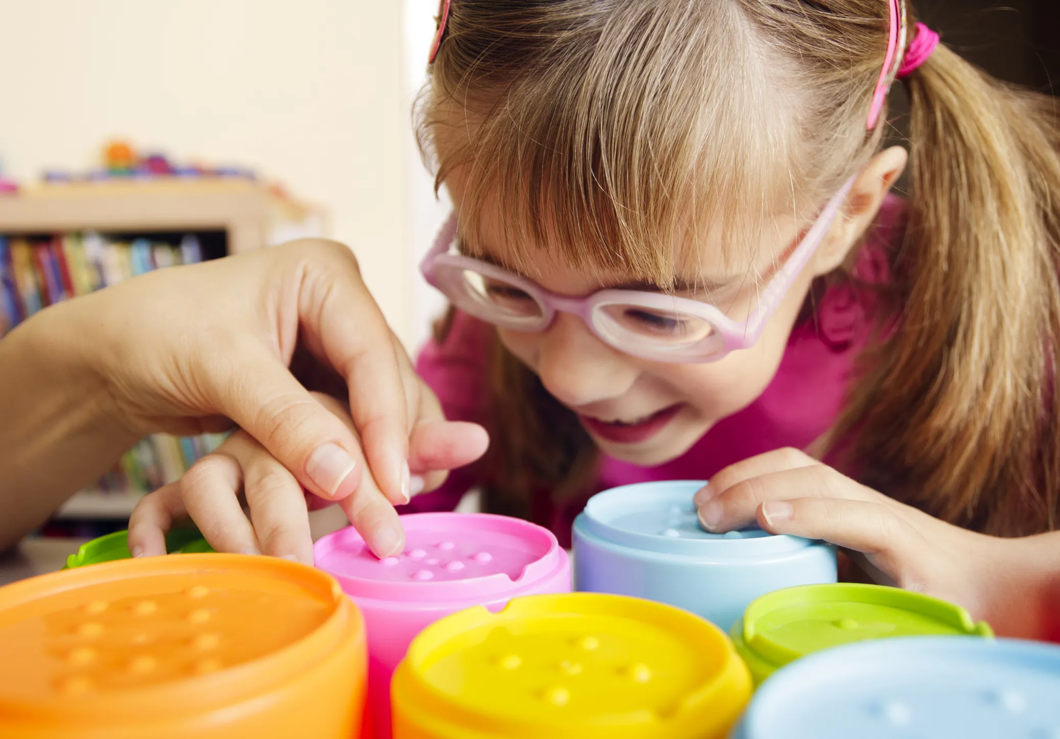 Child engaging in a tactile learning activity with colourful containers