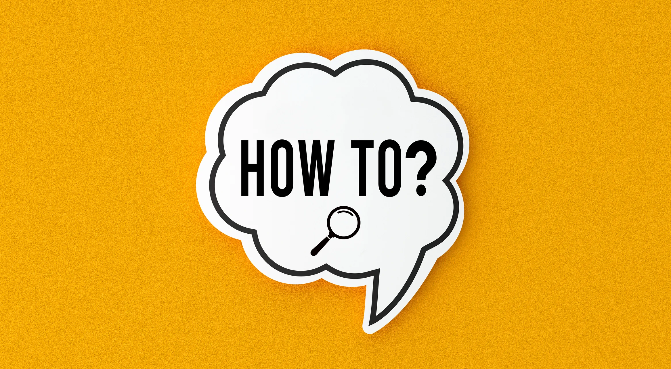 A white speech‑bubble graphic on an orange background containing the text “HOW TO?” with a small magnifying‑glass icon below the words.
