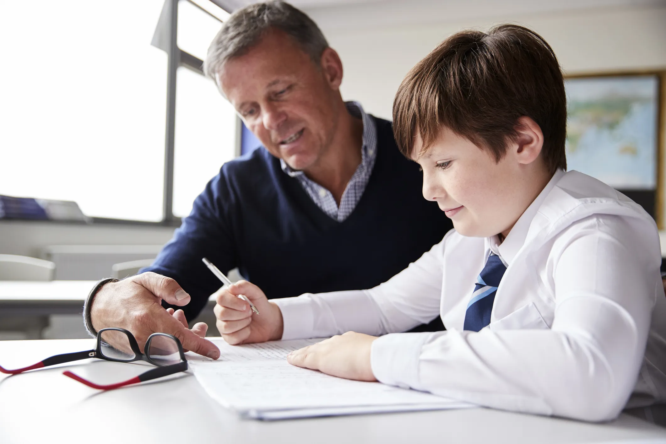 Adult helping a student with schoolwork at a desk