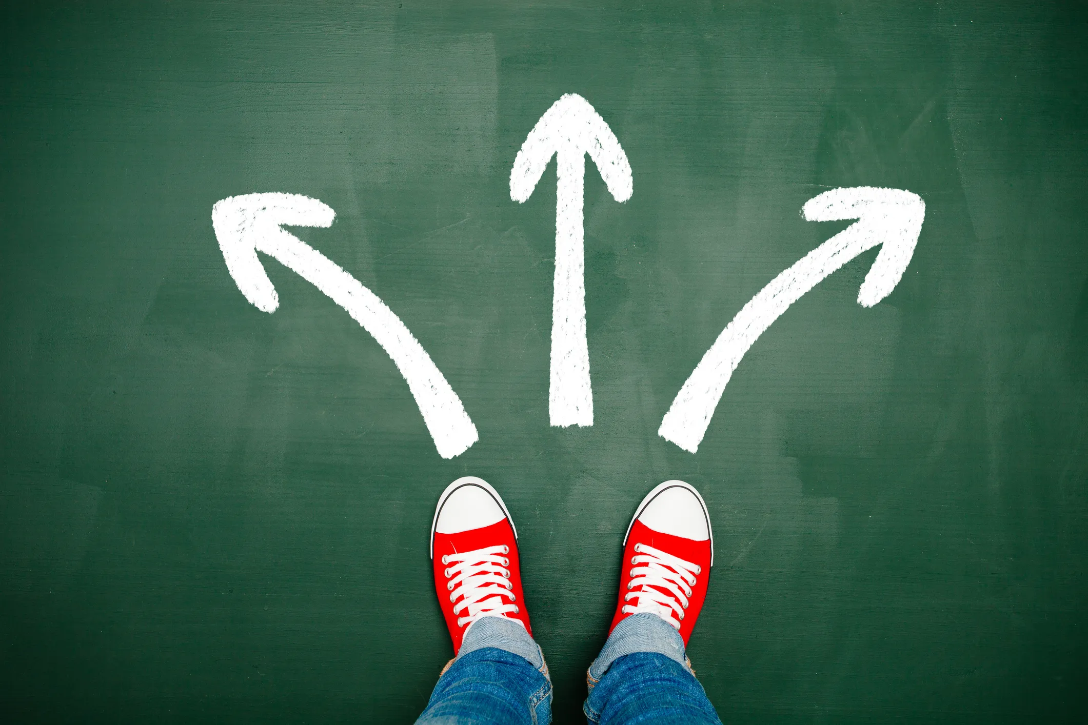 Person standing before three arrows pointing in different directions symbolizing options