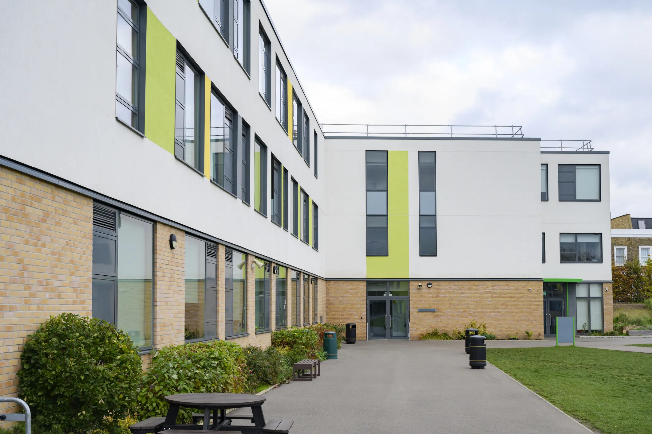 School building and a courtyard with benches and plants