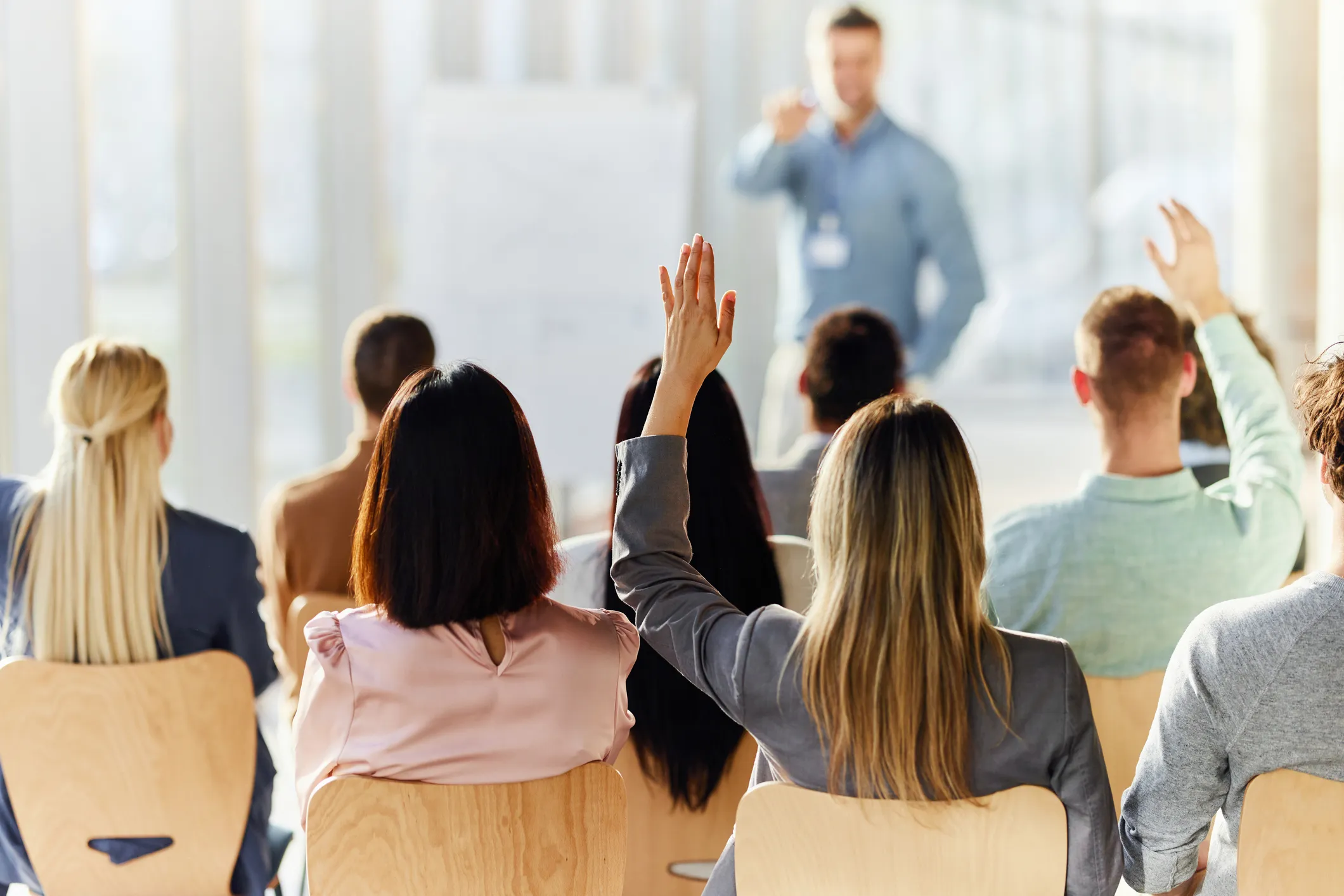 People in a meeting or seminar hands raised