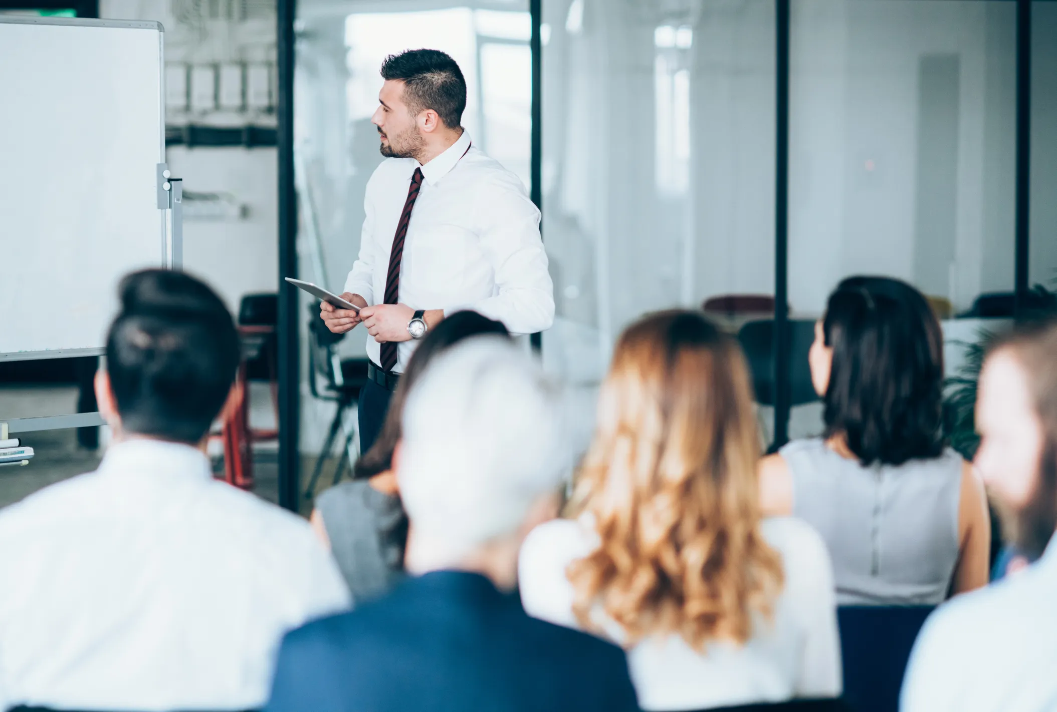 Person giving a presentation to a seated audience in an office setting