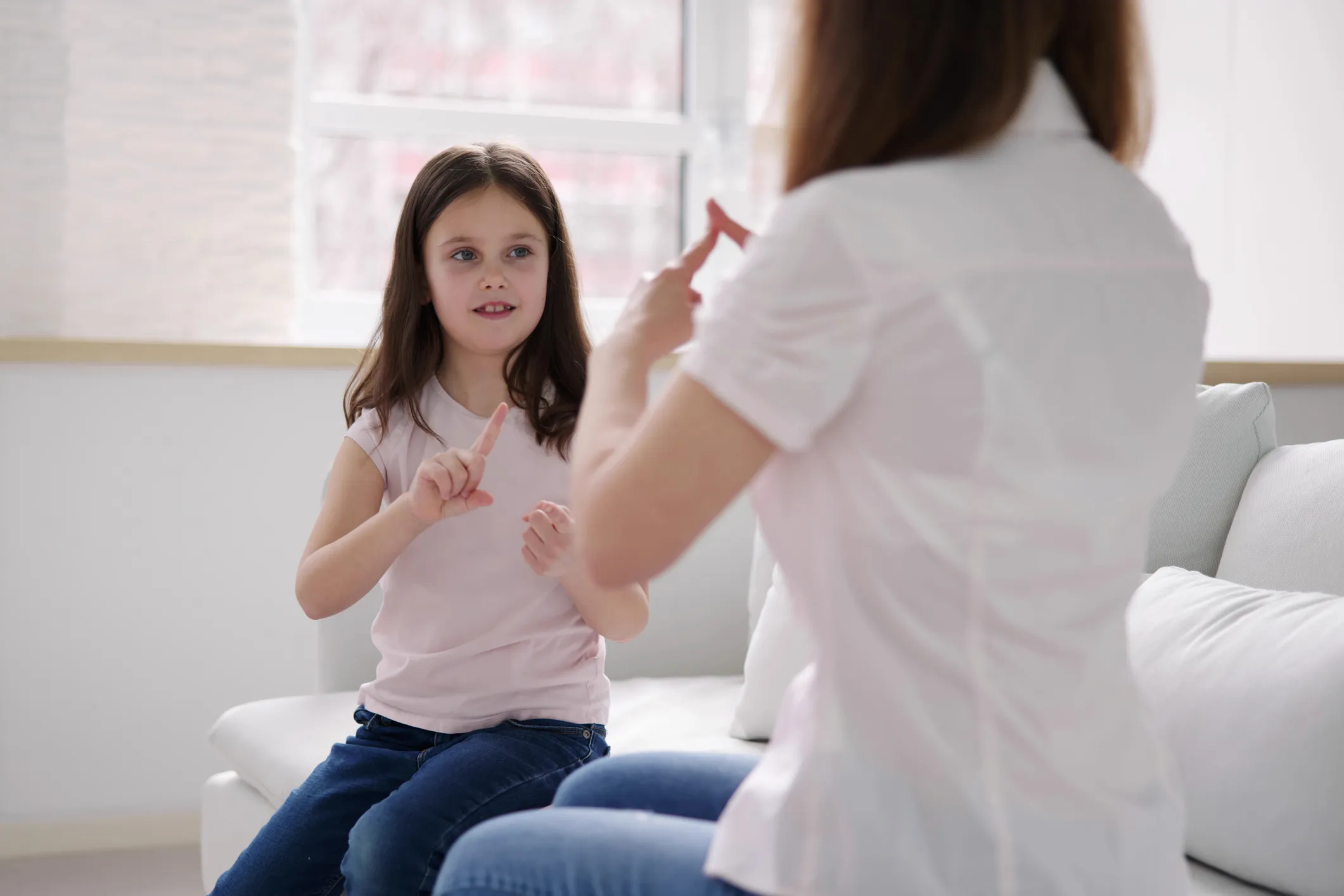 Child and adult communicating in sign language