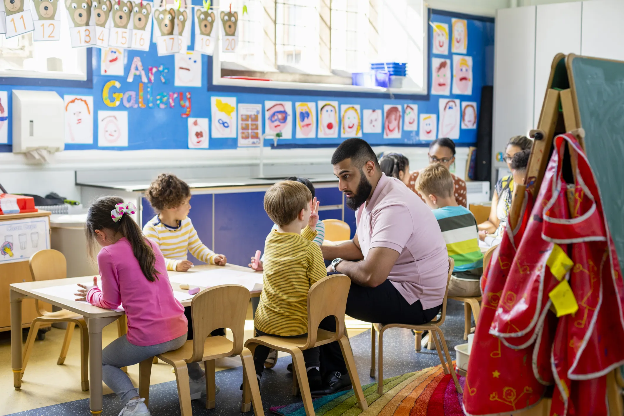 Image of two teachers in a classroom environment with young children